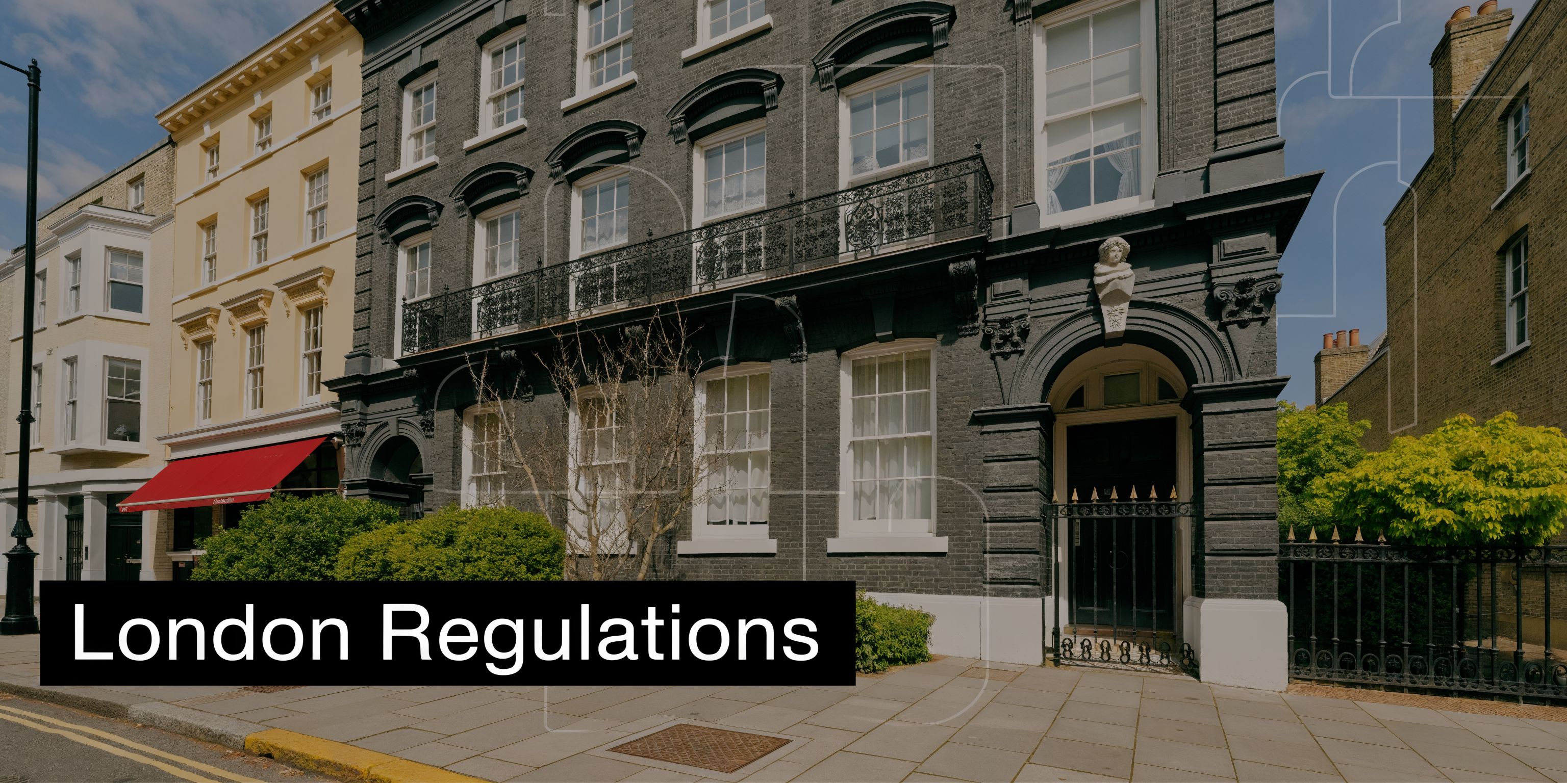A historic dark grey brick London townhouse with white window frames and traditional iron balcony railings.