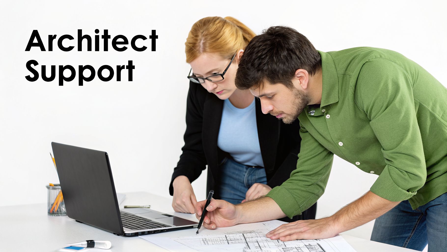 Two architects, a man and a woman, collaborate on blueprints with a laptop on a white desk.