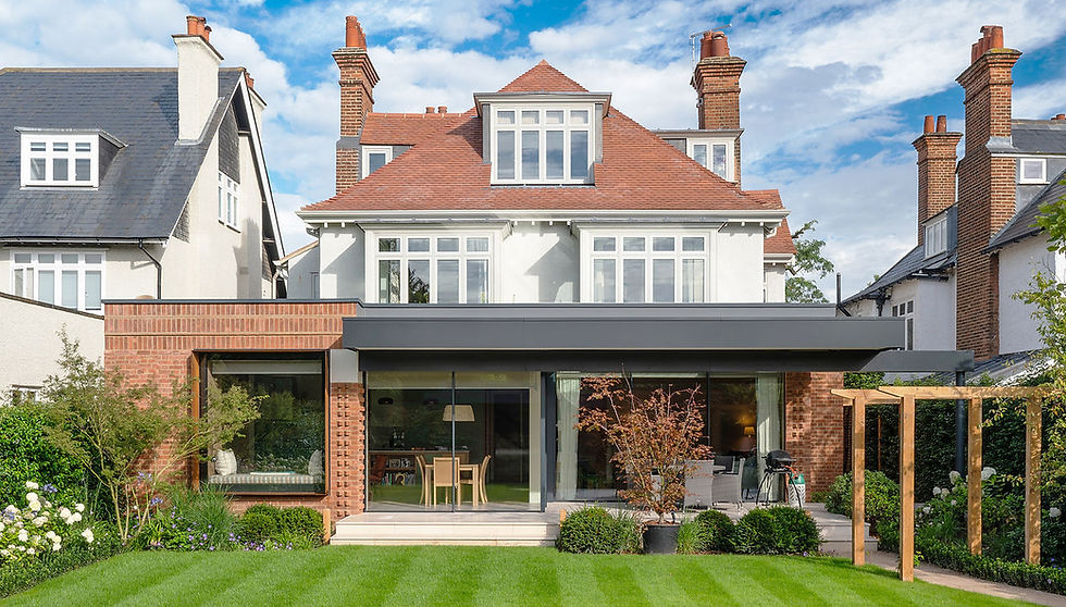 Brick and glazed rear extension beneath a white house with a red tiled roof