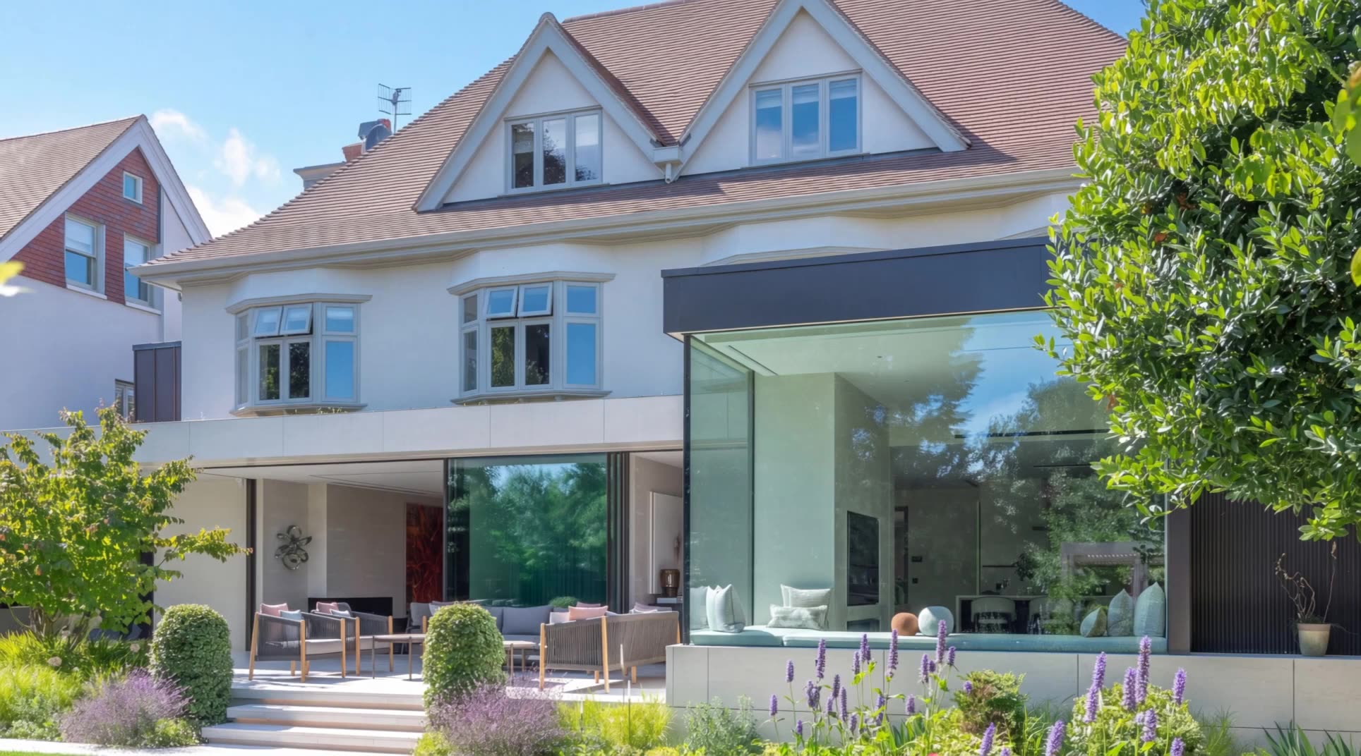 Rear view of a Wimbledon home with a contemporary glass extension, seen from the garden
